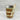 Layered cupcake dessert in a mason jar with a wooden spoon on a marble surface