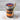 Halloween-themed cupcake dessert treat jar with a wooden spoon on a marble surface.