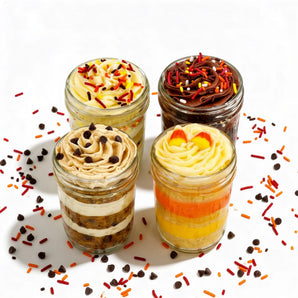 Four layered cupcake dessert jars with colorful toppings on a white background with sprinkles.