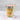 Jar of layered vanilla and pink icing cupcake dessert with a wooden spoon on a marble surface