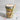 Jar of layered cupcake dessert with a wooden spoon, tied with string, on a marble surface.