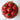 Red apple-shaped cupcakes in a woven basket with a checkered liner on a marble surface.