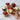 Decorative cupcakes with red and green icing held by a hand on a marble surface