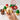 Hand holding a cupcake with Christmas-themed cupcakes in the background
