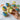 Hand holding a cupcake with others decorated like beach-themed cupcakes on a marble surface
