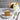 Carrot cake with a slice on a plate, served on a marble surface with a gray background.