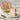 Colorful layered cake with a slice on a plate, placed on a textured surface.