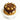 Chocolate cake with decorative swirls sprinkled with peanuts and piped icing on a white stand