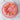 Pink cake with ruffled edges and colorful sprinkles on a marble surface