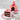 Pink and chocolate cake with a slice on a plate, on a marble surface.