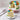 Decorative cake with colorful flowers on a marble surface, with a slice cut out and placed on a plate.