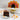 Chocolate cake with a slice on a plate, surrounded by candy corn, with a decorated cake resembling a turkey in the background.